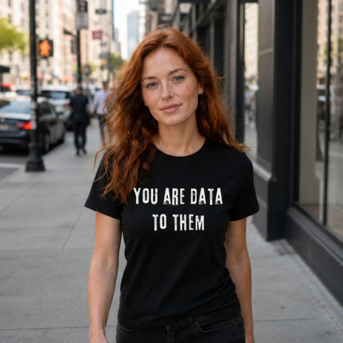 Woman wearing black "You Are Data To Them" graphic t-shirt outdoors