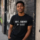 Man wearing black "Grift Currency Of Elites" graphic t-shirt outdoors